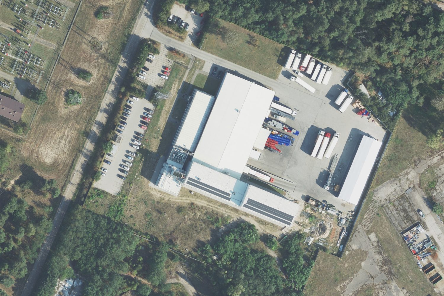 Zakład Carnis przy ulicy Zachodniej 5 w Kole z lotu ptaka: hale, plac załadunkowy z naczepami chłodniczymi, parking